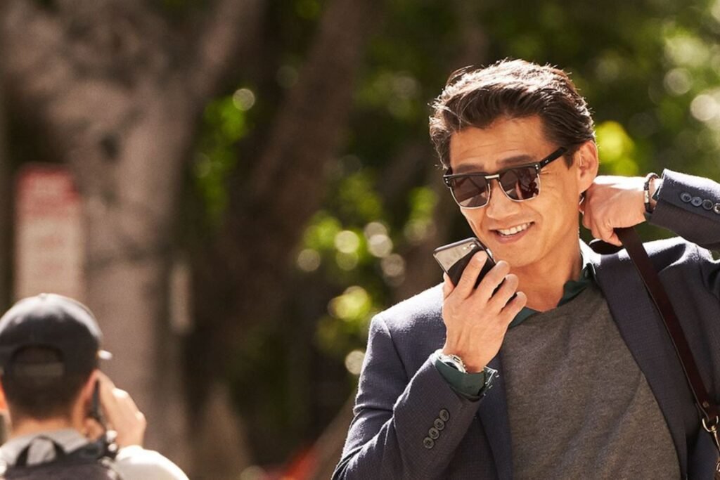 صورة لشخص بيده هاتف يتحدث ويبتسم